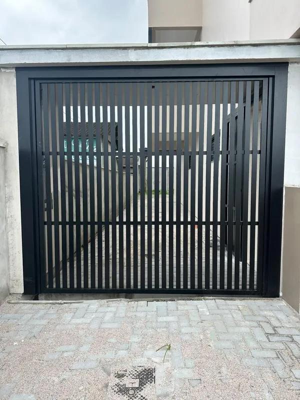 Portão deslizante em alumínio preto com venezianas verticais