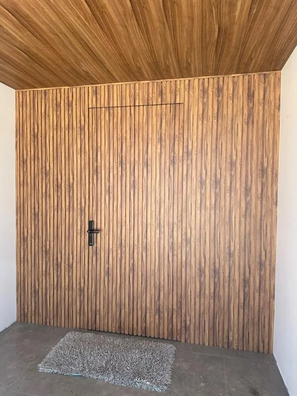 Painel amadeirado com porta integrada e forro – entrada sofisticada